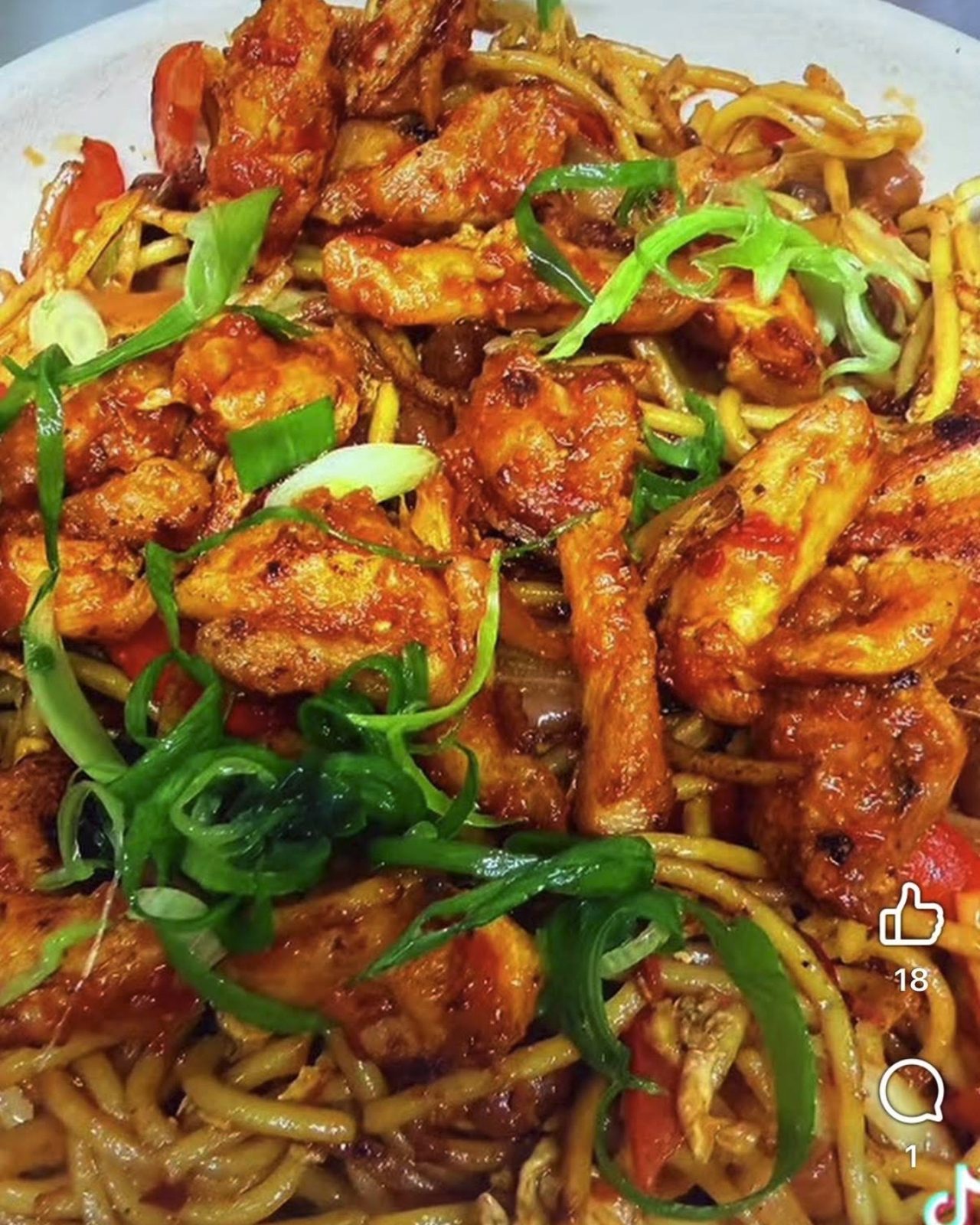 Amilo Piro chicken choila chowmein, noodles under charred chicken and sliced spring onion